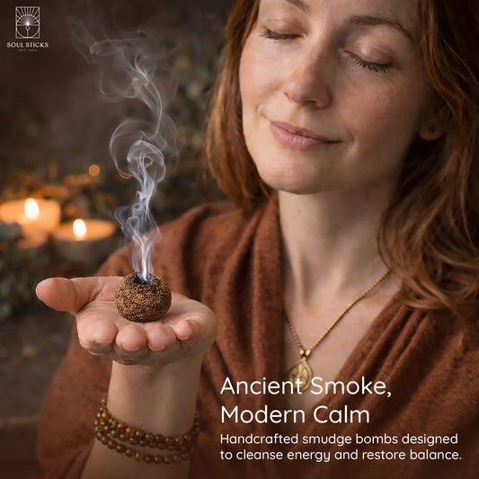Hand holding a lit frankincense & myrrh smudge bomb with smoke