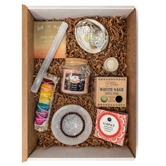 Box containing various items including a candle, beads, and a shell on a white background