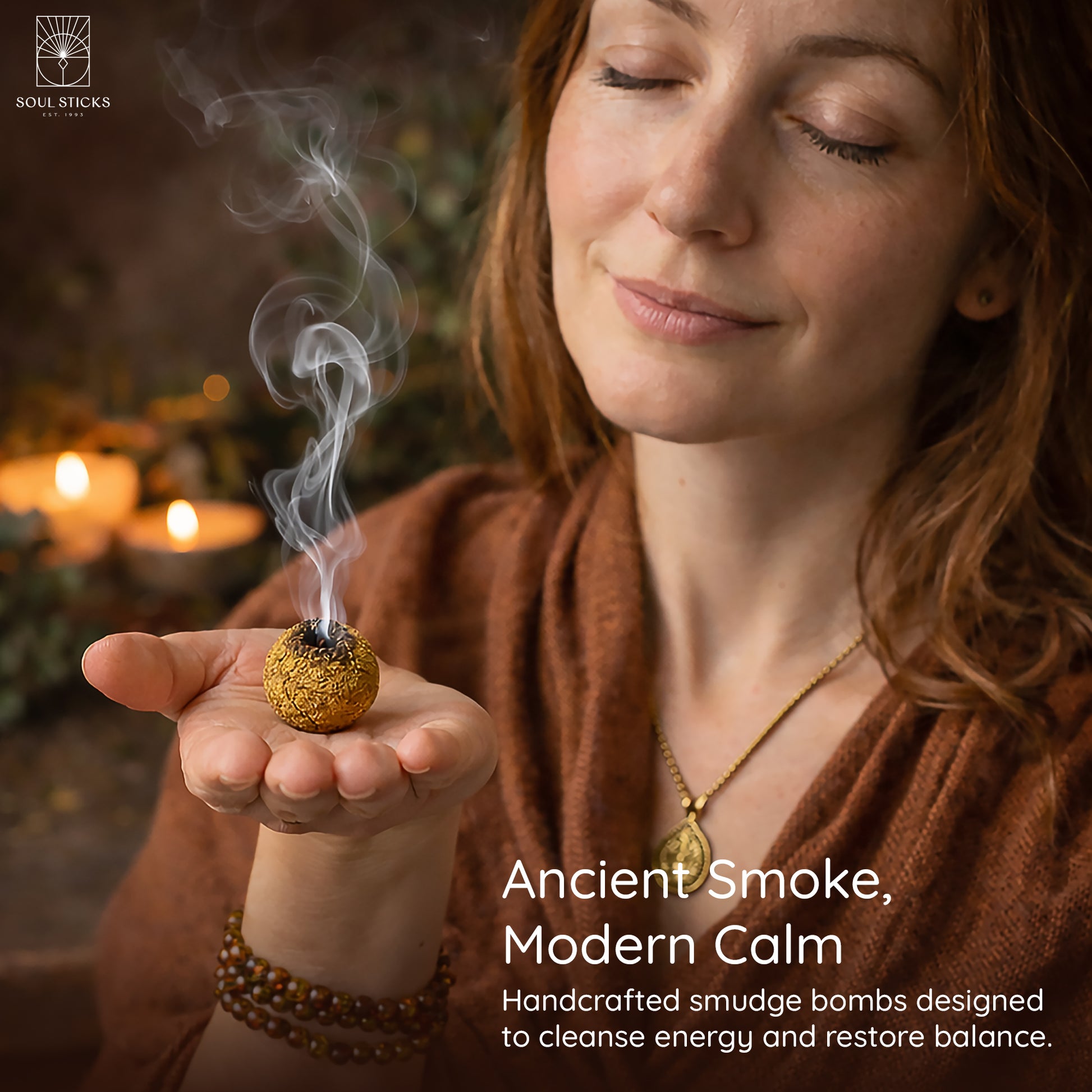 Hand holding a lit amber vanilla smudge bomb with smoke