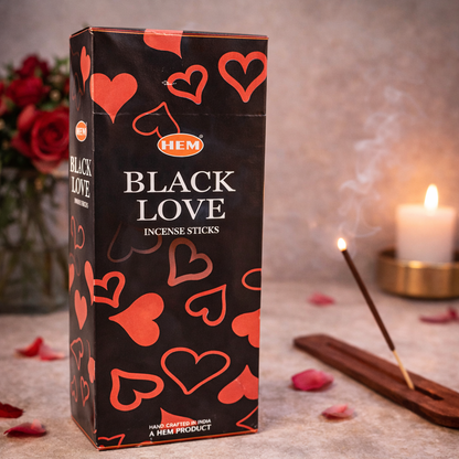 HEM Black Love incense sticks box with burning incense, candle, and rose petals