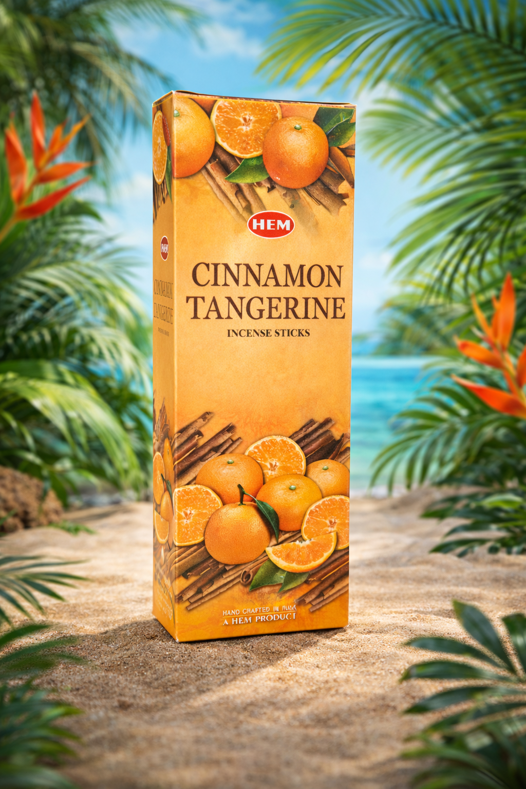 HEM Cinnamon Tangerine incense sticks box on sandy beach with tropical leaves and ocean background