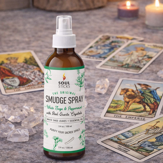 Smudge spray bottle labeled 'Soul Sticks' on a surface with tarot cards and crystals.