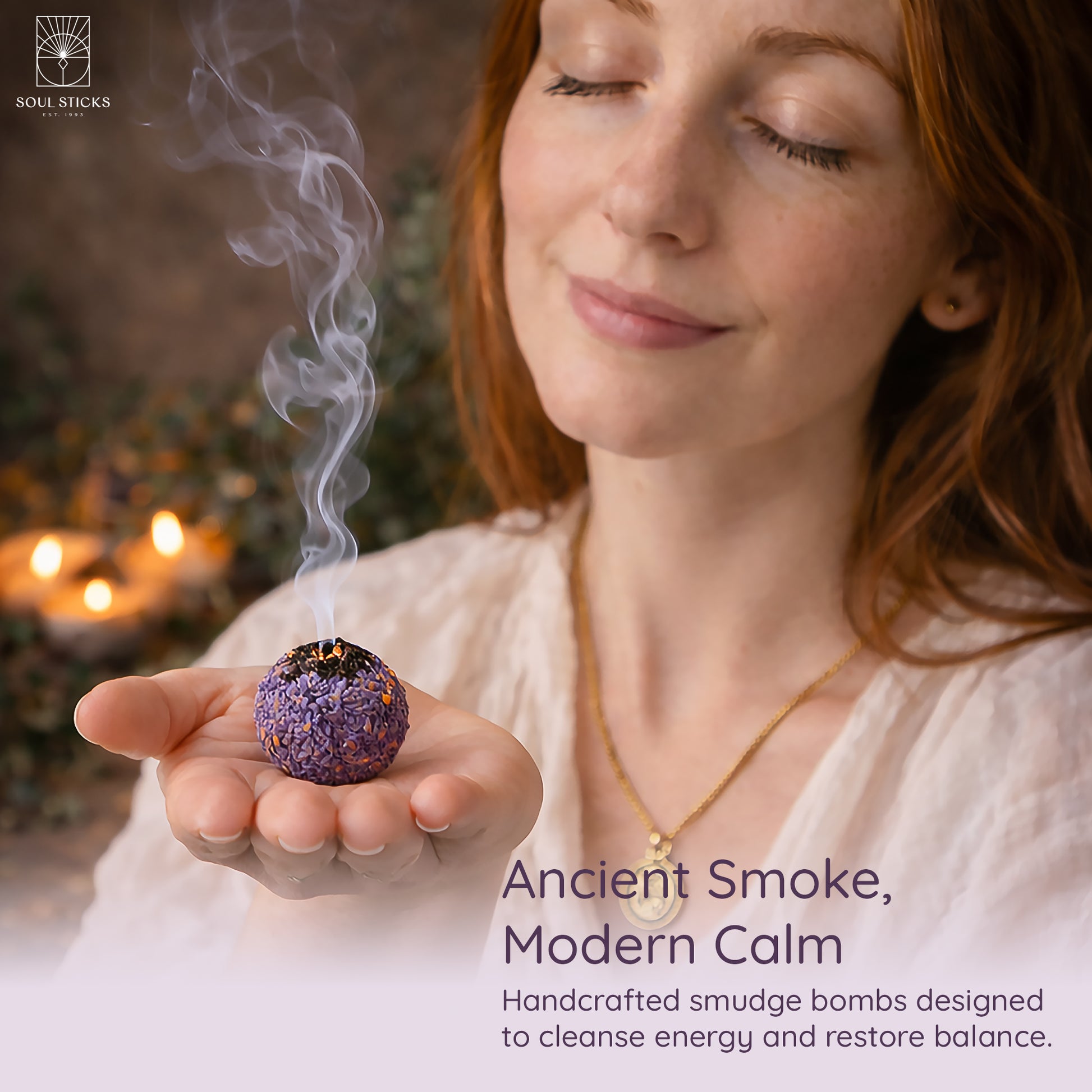 Hand holding a lit lavender smudge bomb with smoke