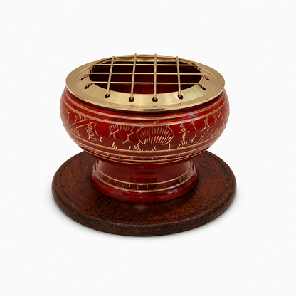 Red decorative incense burner with gold detailing and a brass screen top, displayed on an ornate round wooden coaster against a white background.