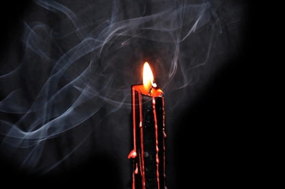 Decorative ritual bleeding candle with dripping wax for magical and mystical intentions.