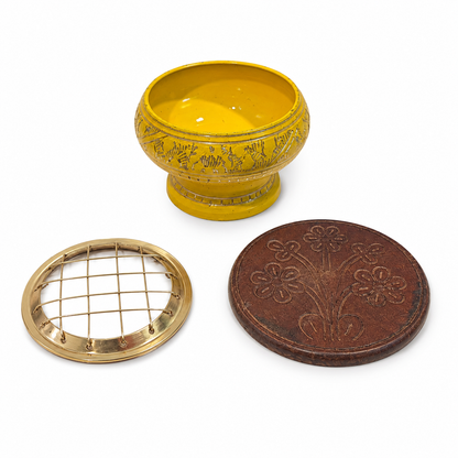 Yellow incense burner set with gold detailing, removable brass screen top, and round carved wooden coaster, shown as three separate pieces on a white background.