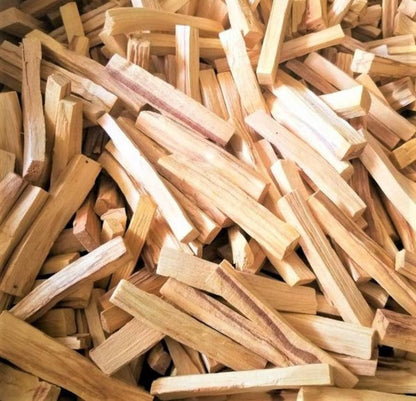 A pile of light beige Palo Santo smudge sticks with a rough, rustic texture.